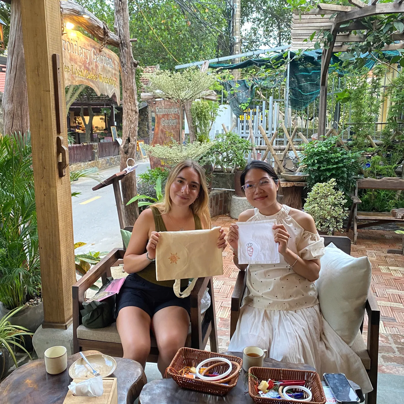 Travelers holding souvenirs they embroidered themselves in Tam Coc