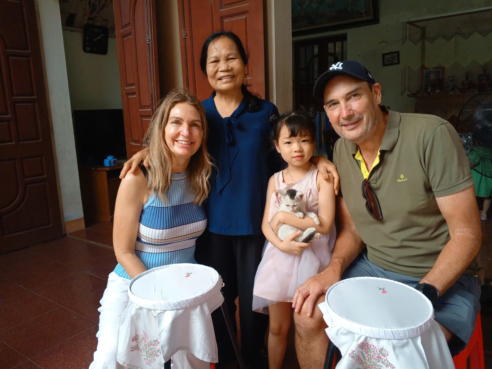 Dinh Thi Nguyen with a visiting family during an embroidery session in Van Lam Village