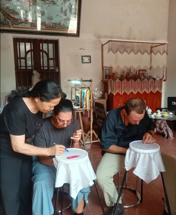 A different group of guests concentrating on hand embroidery at a workshop in Tam Coc